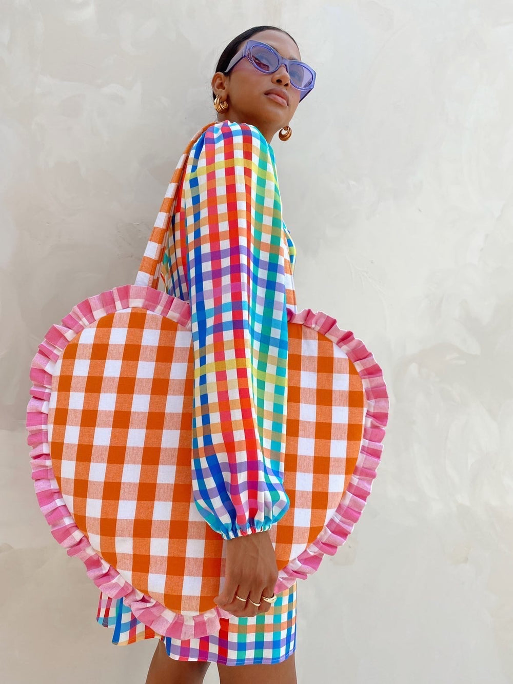 Person wearing a colorful checkered dress with a heart-shaped orange and pink checkered bottom section.