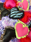 Colorful heart-shaped keyrings with various patterns and textures.